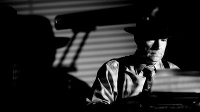 stock-footage-a-man-in-a-fedora-typing-on-a-vintage-manual-typewriter-film-noir-style-lighting